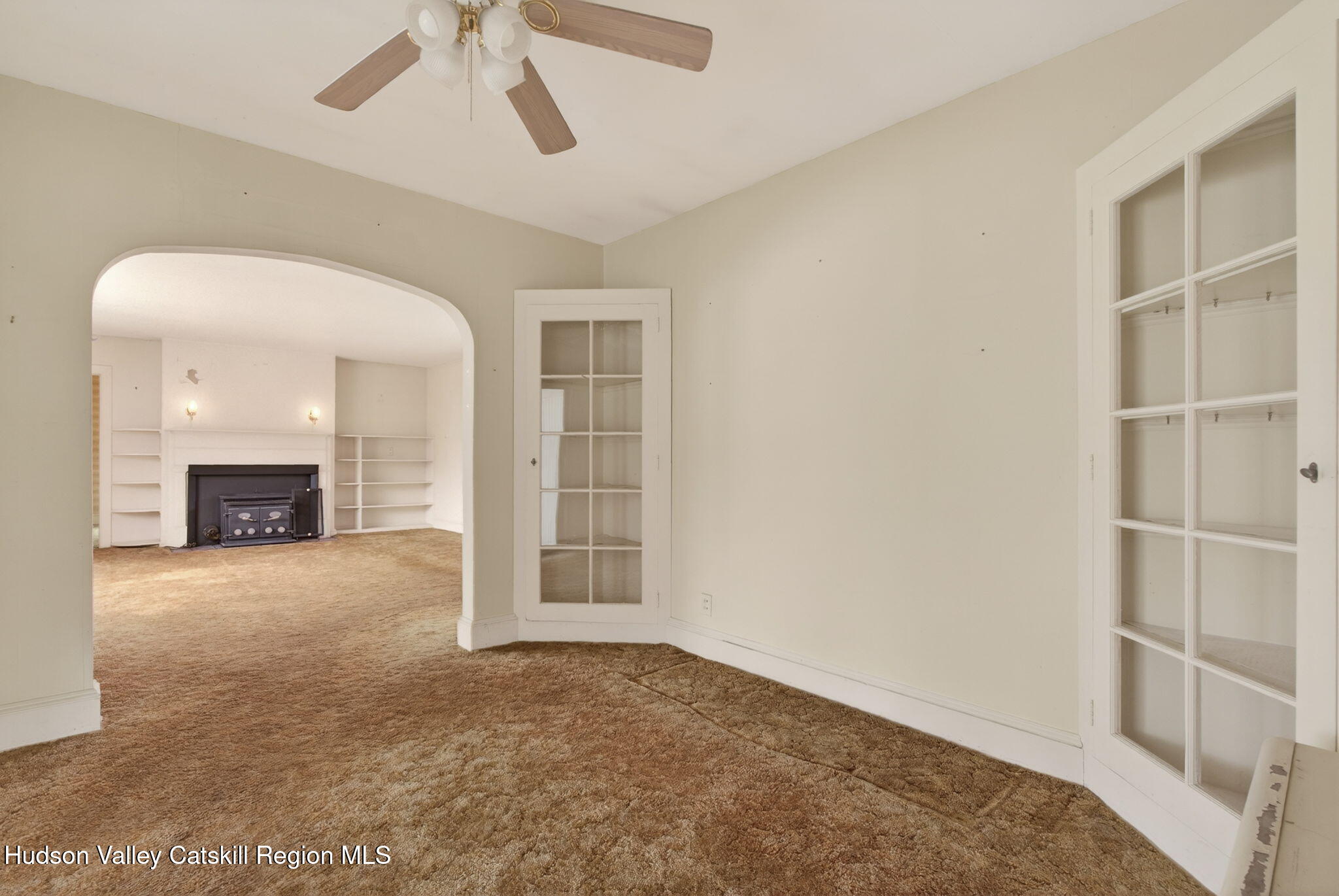 85 Harding Avenue Kingston, NY 12401 - Photo 7 of 41 an empty room with windows fireplace and a ceiling fan