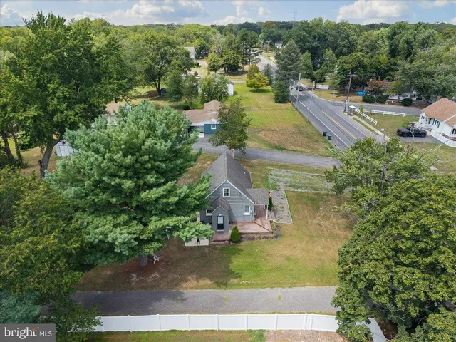 an aerial view of residential houses with outdoor space and trees