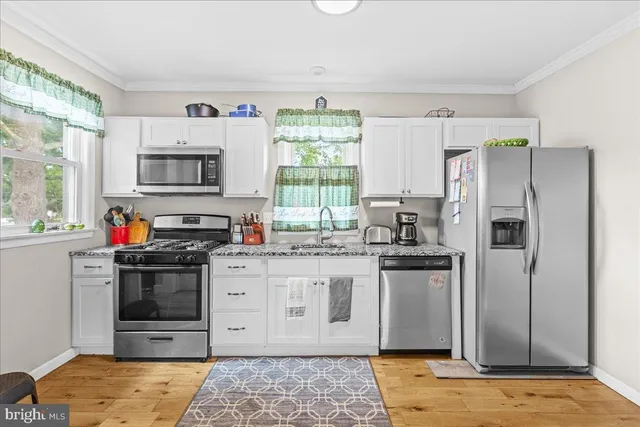 a kitchen with stainless steel appliances granite countertop a stove a sink and a refrigerator