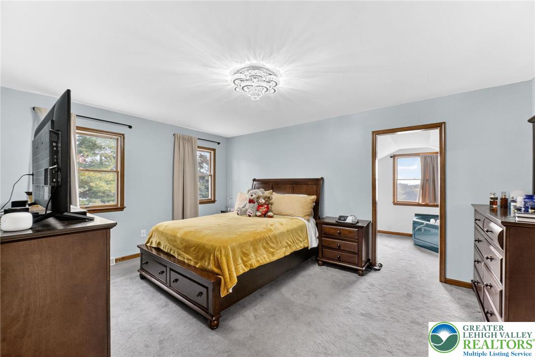 3746 Apple Road Orefield, PA 18069 - Photo 18 of 40 a bedroom with a bed and a chandelier