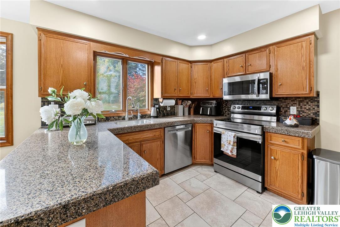3746 Apple Road Orefield, PA 18069 - Photo 9 of 40 a kitchen with stainless steel appliances granite countertop a sink a stove top oven a counter space and cabinets