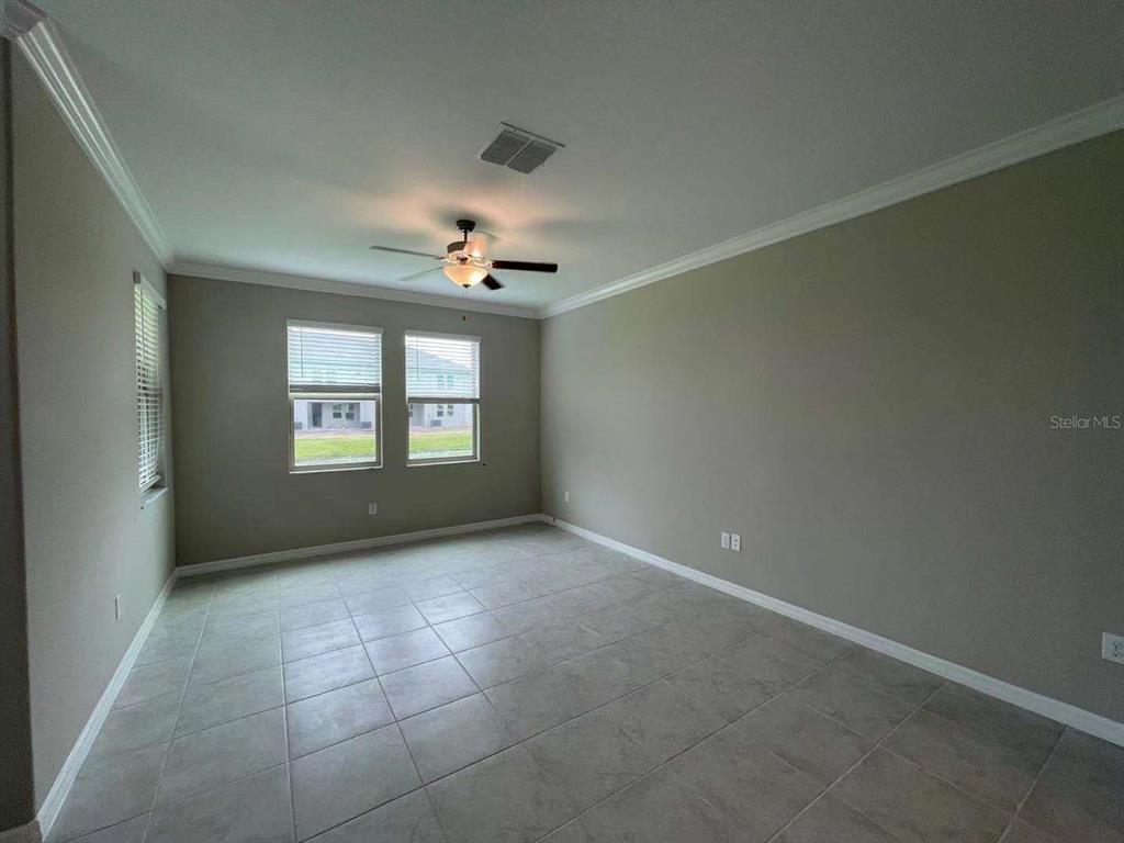 31993 Blue Passing Loop Wesley Chapel, FL 33545 - Photo 5 of 17 an empty room with windows and fan