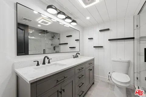 a bathroom with a toilet a sink and mirror