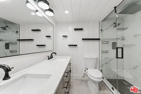 a bathroom with a sink a toilet and a mirror