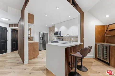 a kitchen with stainless steel appliances granite countertop a refrigerator and a stove top oven
