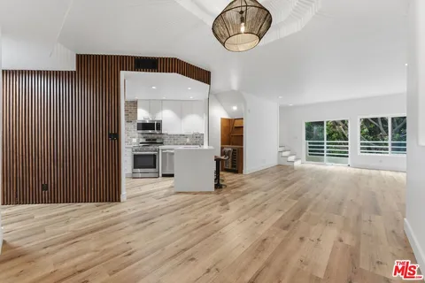 a view of a kitchen with wooden floor and a large window