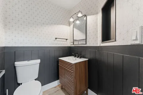 a bathroom with a sink a toilet and mirror
