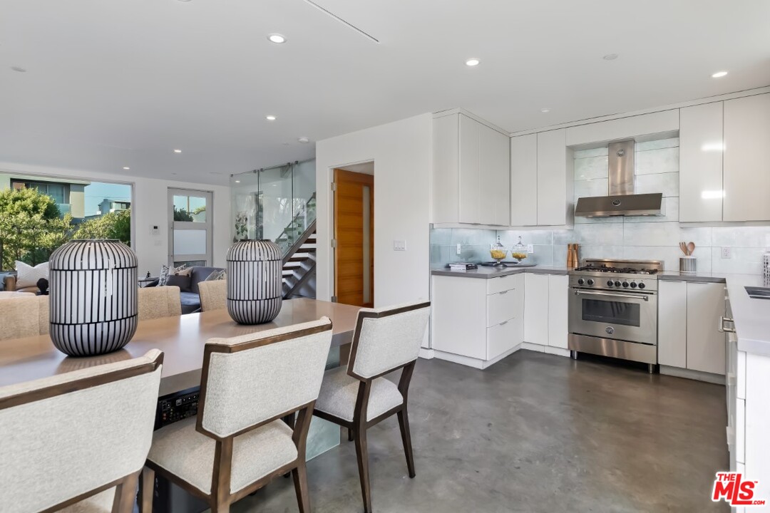 808 Brooks Avenue Venice, CA 90291 - Photo 17 of 47 a kitchen with stainless steel appliances kitchen island granite countertop a stove a sink a refrigerator and white cabinets with wooden floor