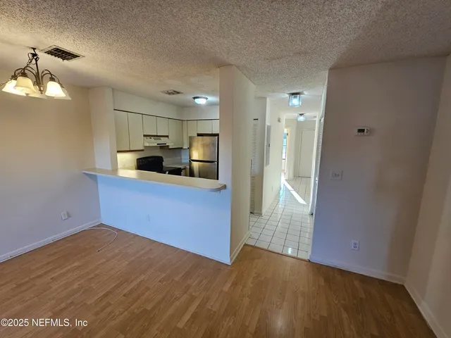a kitchen with stainless steel appliances kitchen island granite countertop a refrigerator and a sink