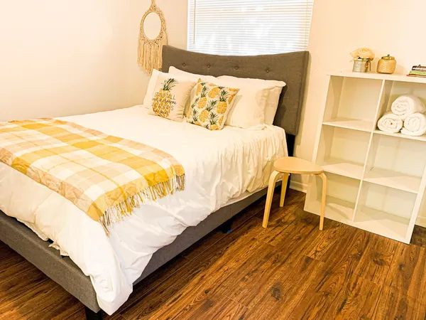 a bedroom with a bed and wooden floor