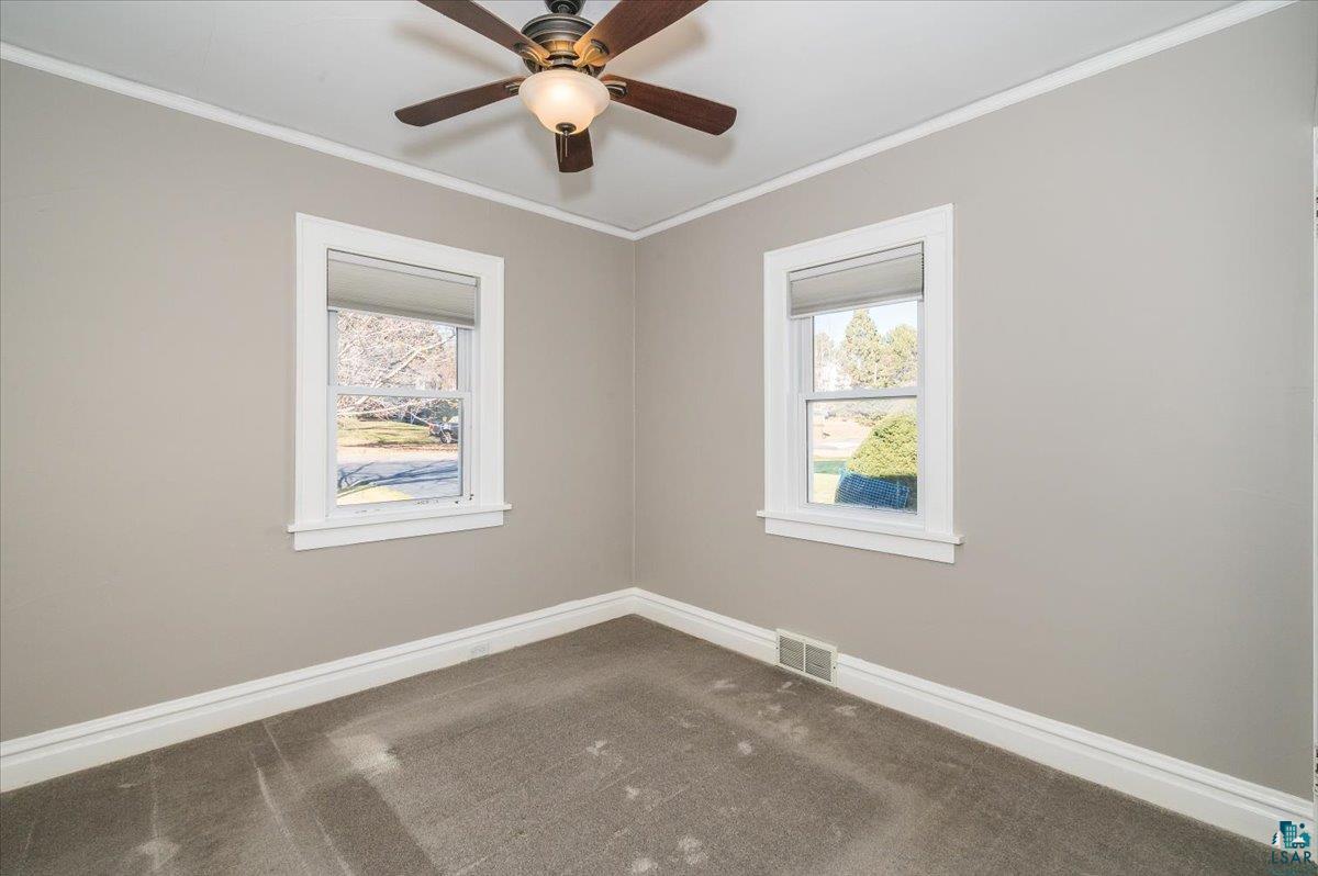 1906 Springvale Road Duluth, MN 55811 - Photo 12 of 15 Carpeted spare room featuring crown molding and ceiling fan