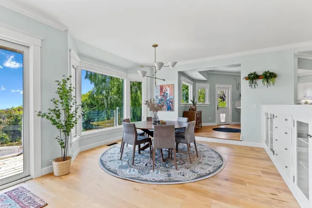 a kitchen with stainless steel appliances granite countertop a sink a stove a dining table and chairs