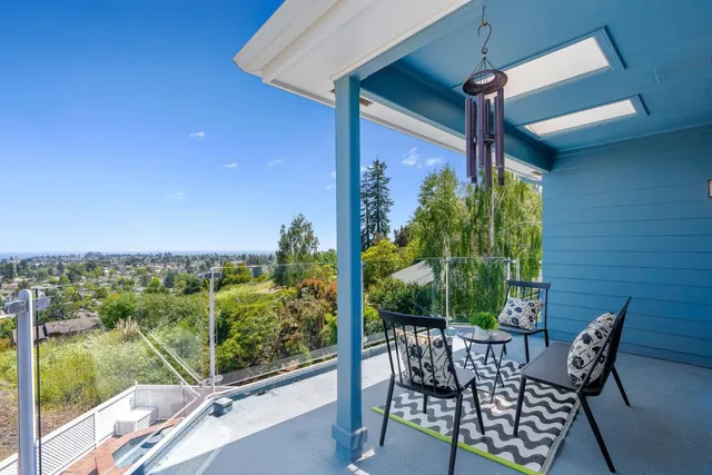 a view of a roof deck with couches and wooden floor