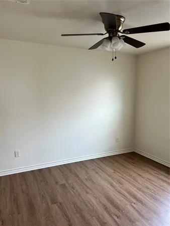 a view of a room with wooden floor and fan