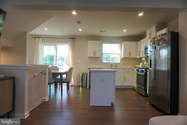 a kitchen with refrigerator cabinets dining table and chairs