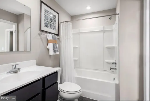 a bathroom with a bathtub shower sink mirror vanity and toilet
