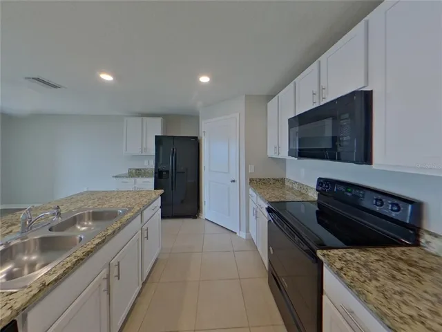 a kitchen with granite countertop stainless steel appliances and wooden cabinets