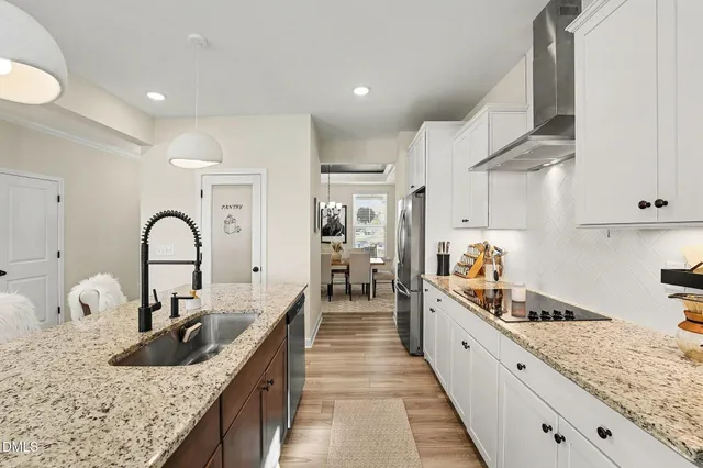a large kitchen with granite countertop a sink and cabinets
