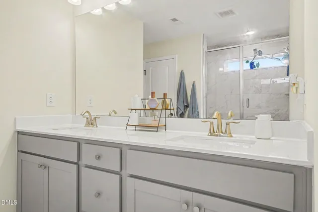 a bathroom with a sink double vanity granite tub shower and a mirror