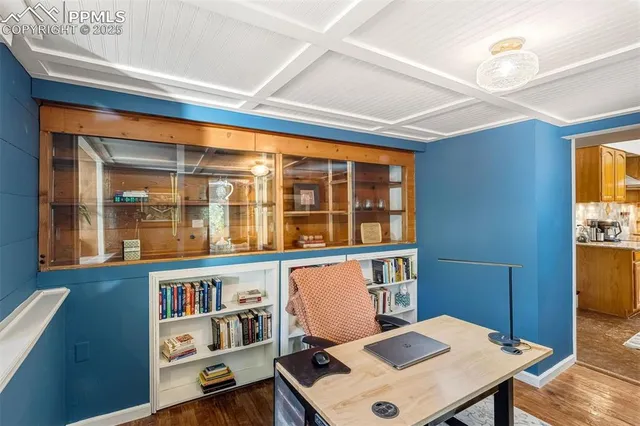 a view of a workspace with furniture and a window