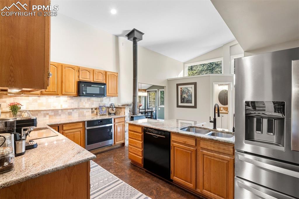 1144 Rock Creek Canyon Road, Unit A Colorado Springs, CO 80926 - Photo 15 of 50 a kitchen with stainless steel appliances granite countertop a sink stove and refrigerator