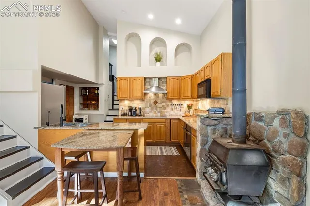 a dining hall with stainless steel appliances granite countertop a stove and refrigerator