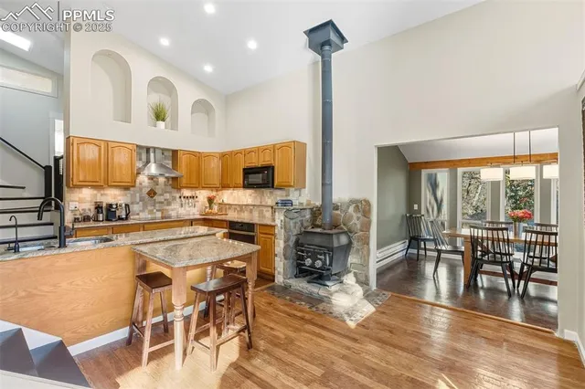 a kitchen with stainless steel appliances wooden floor dining table and chairs