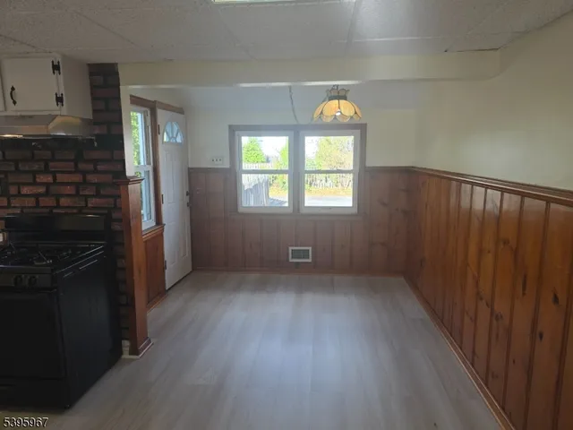 an empty room with wooden floor a fireplace and windows