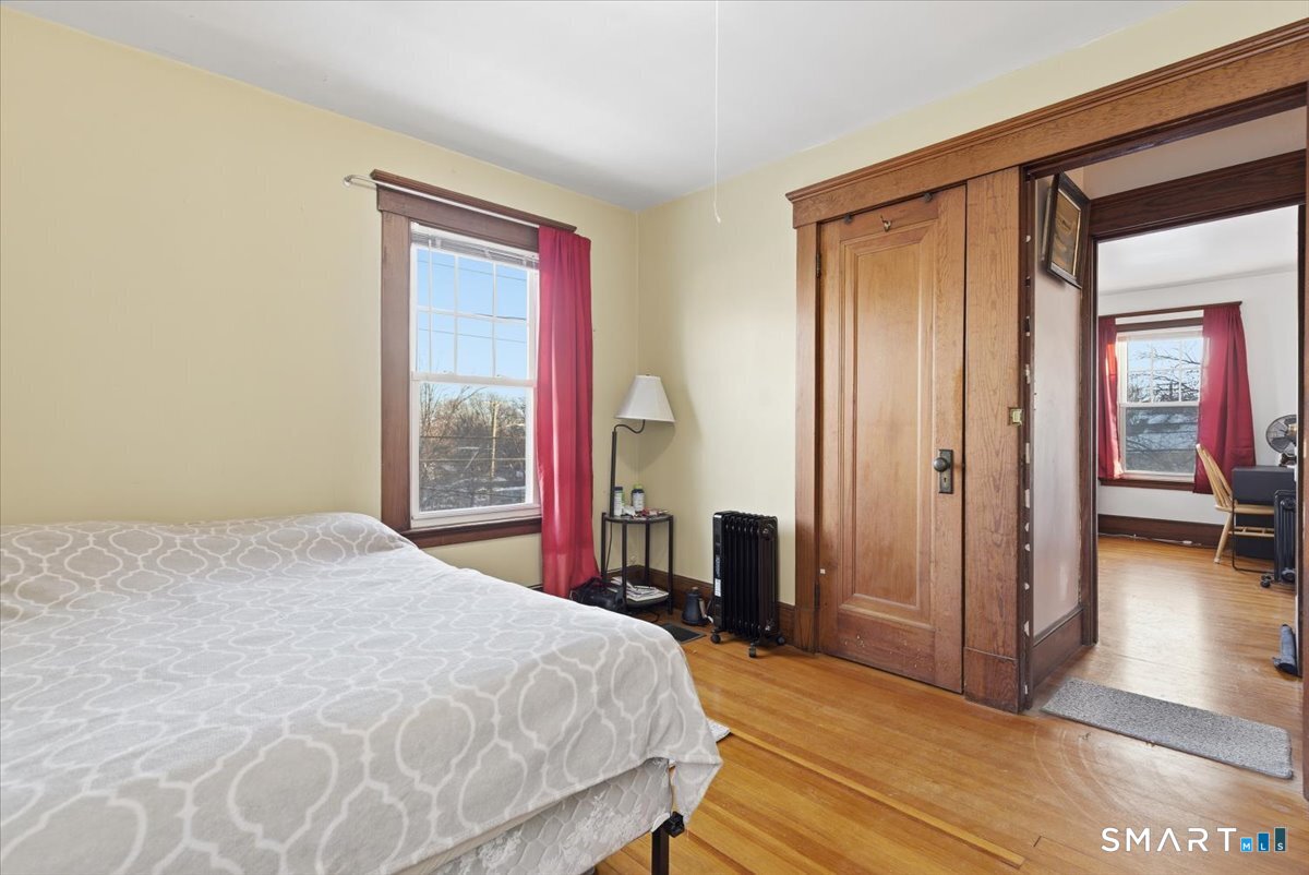 93 Cannon Street Hamden, CT 06518 - Photo 16 of 38 a bedroom with a bed and a large mirror next to a window