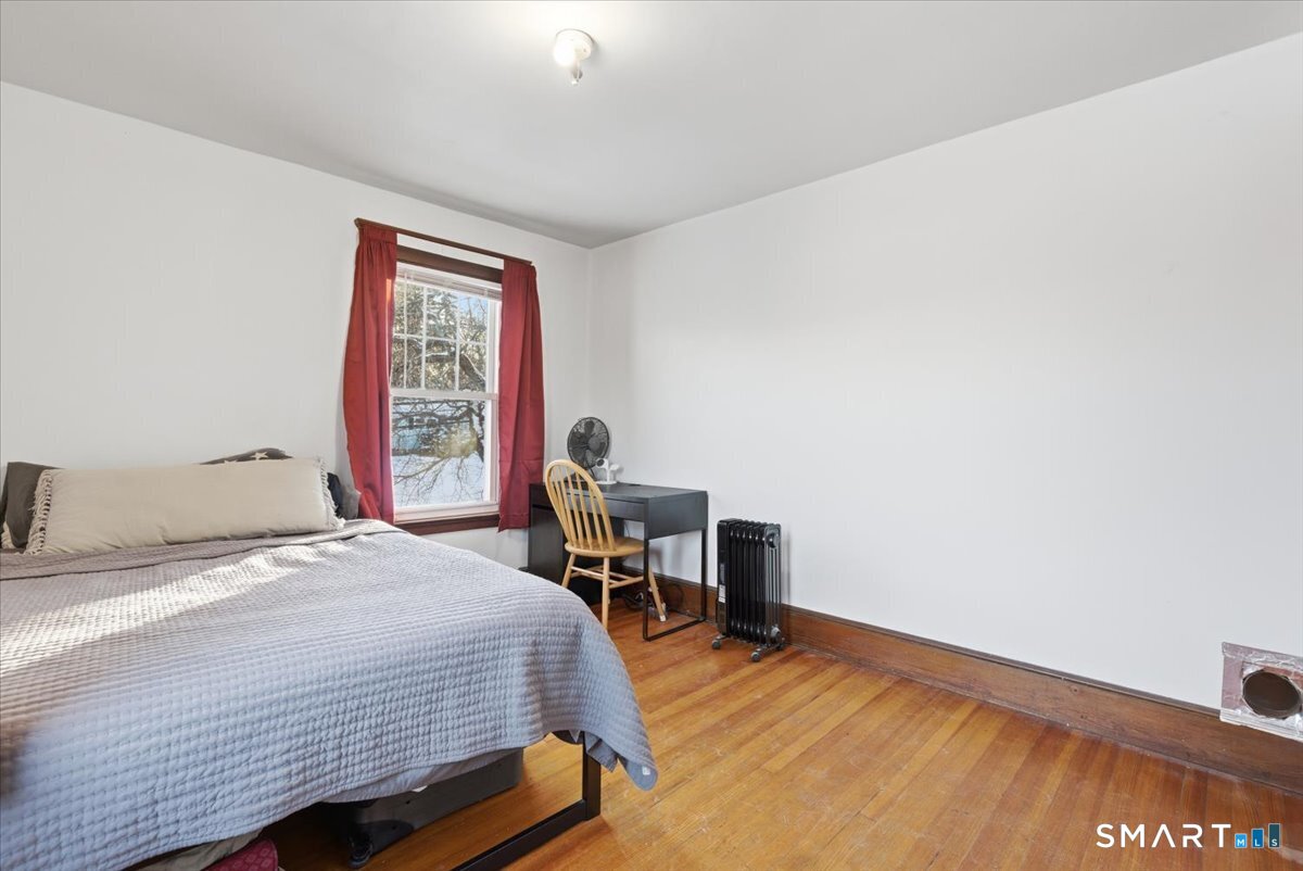 93 Cannon Street Hamden, CT 06518 - Photo 19 of 38 a bedroom with a bed a table in it and next to a window