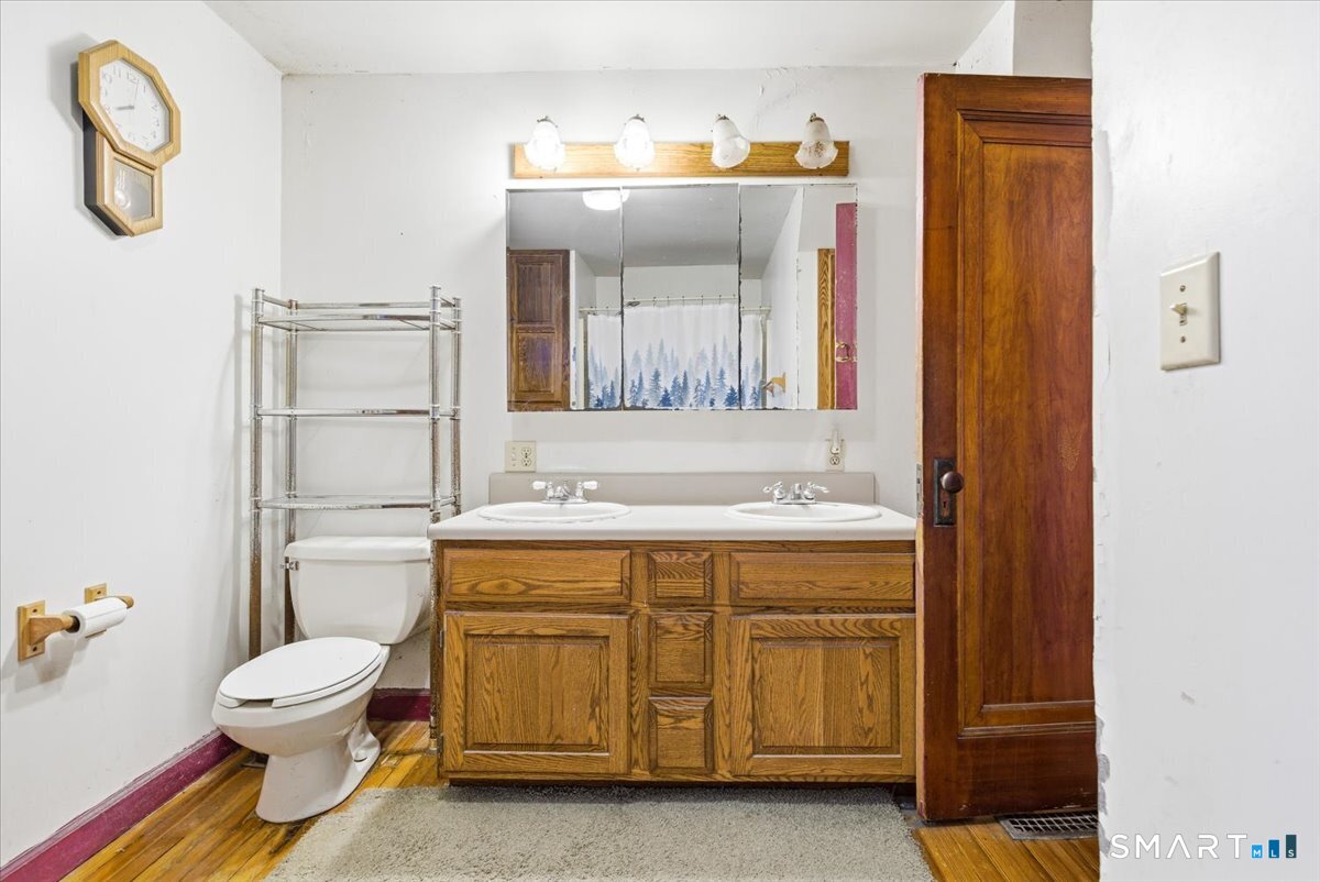 93 Cannon Street Hamden, CT 06518 - Photo 21 of 38 a bathroom with a sink a toilet and a mirror