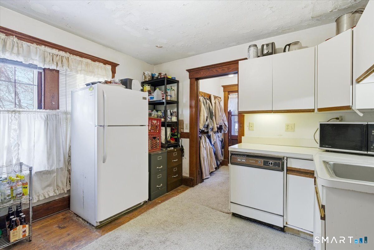 93 Cannon Street Hamden, CT 06518 - Photo 10 of 38 a kitchen with a refrigerator a stove top oven a counter space and a window