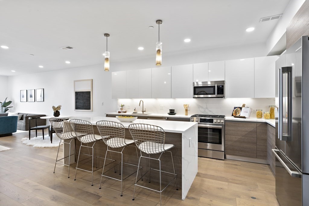 30 Penniman Road, Unit 408 Boston, MA 02134 - Photo 2 of 5 a kitchen with appliances a sink a counter top space and cabinets