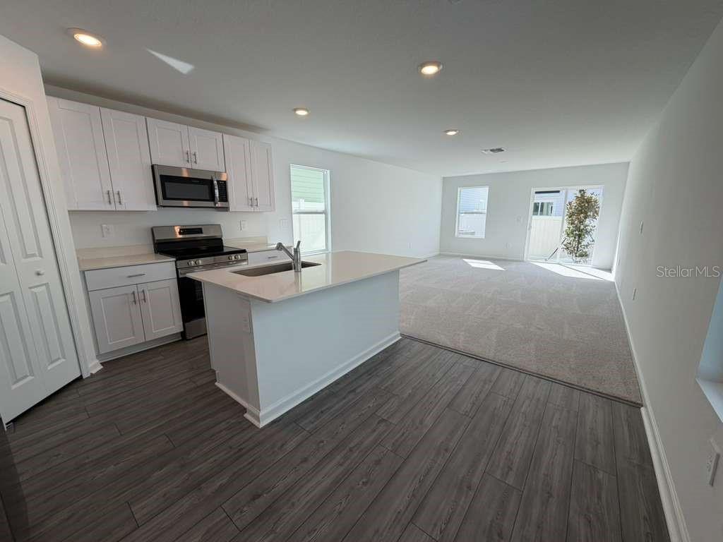 7194 Southwest 91st Lane Ocala, FL 34476 - Photo 19 of 20 a kitchen with granite countertop a sink cabinets and wooden floor