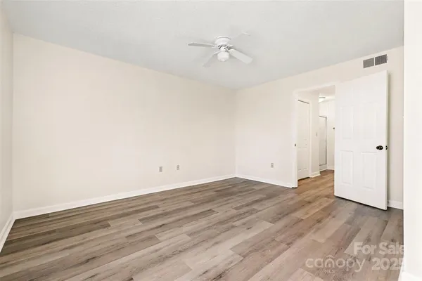 a view of a room with wooden floor and a ceiling fan