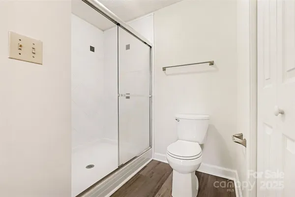 a bathroom with a toilet and a shower