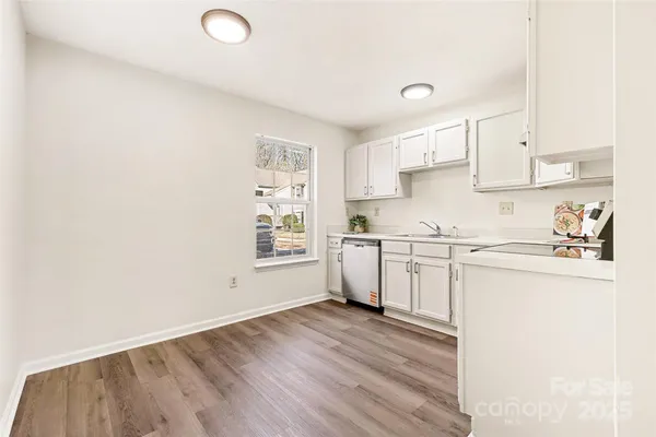 a kitchen with granite countertop white cabinets and white appliances