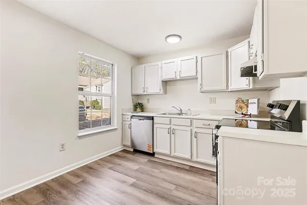 a kitchen with cabinets appliances a sink and a window