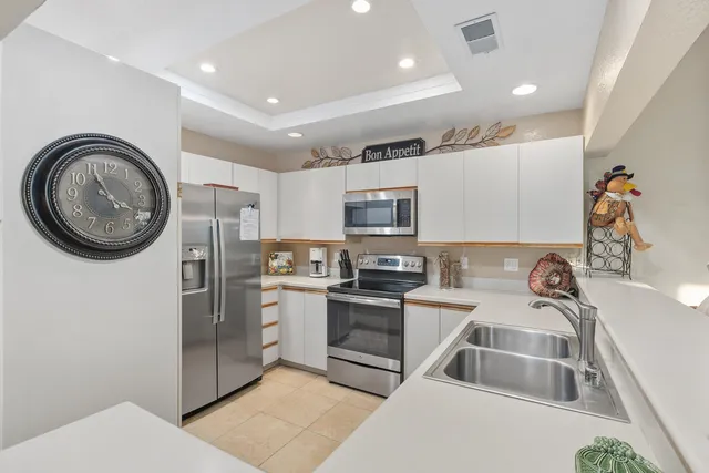 a kitchen with a sink a stove top oven and refrigerator