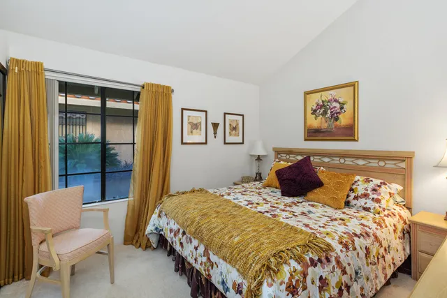 a bedroom with a large bed and a chair