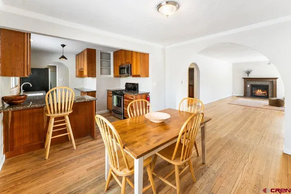 a dining room with furniture a fireplace and wooden floor