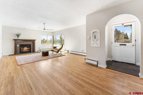 wooden floor fireplace and windows in an empty room