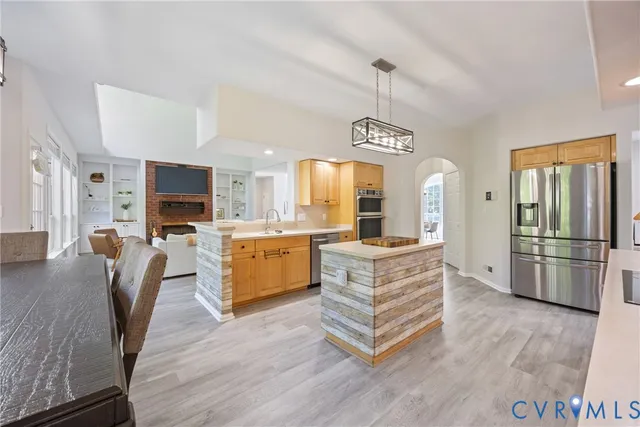 a large kitchen with a table chairs refrigerator and cabinets