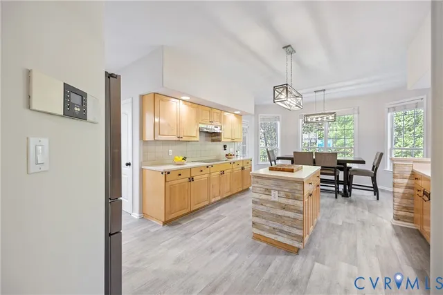 a kitchen with wooden floors and white cabinets