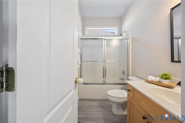 a bathroom with a granite countertop toilet a sink and a shower