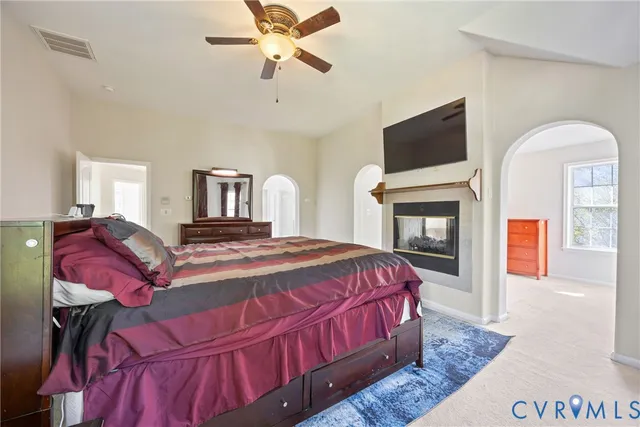 a bedroom with a bed a flat screen tv and chandelier