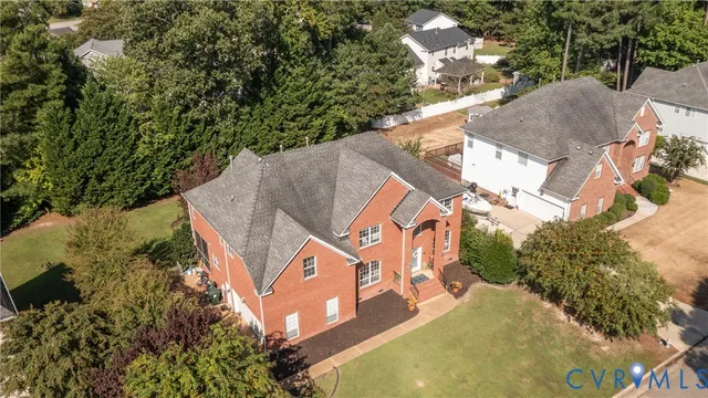 an aerial view of a house with a yard and trees