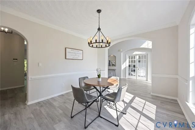 a dining room with furniture a chandelier and wooden floor