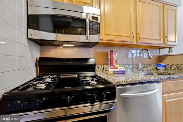 a kitchen with granite countertop stainless steel appliances and white cabinets