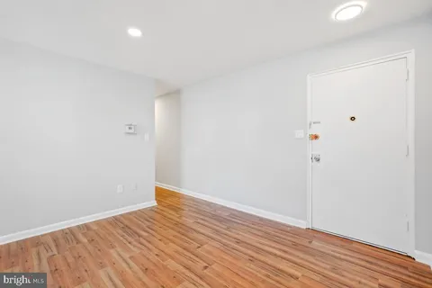 a view of an empty room with wooden floor